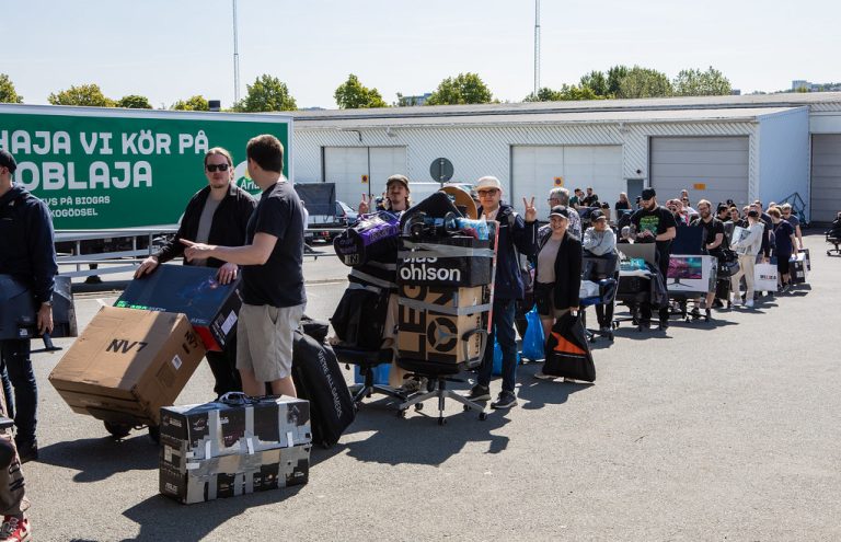 People with computers and screens queueing outside the entrance to Glitched